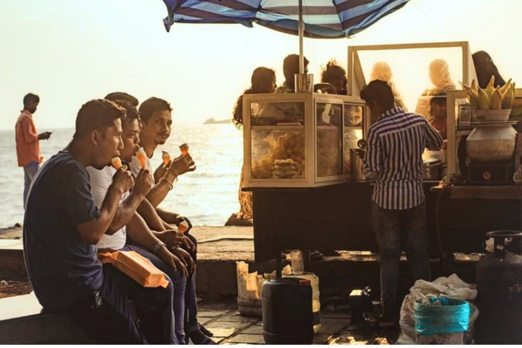 People stopping at a street-food stall in an Indian market.